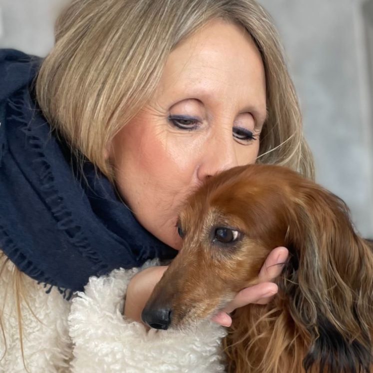 Eine Frau küsst einen Hund zum Abschied vor dem Termin im Salon & Spa von Dée Scherer